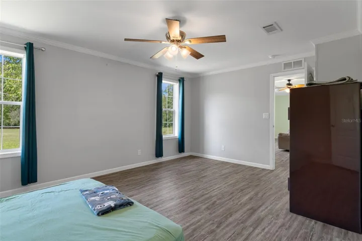 Primary suite with LVP flooring, walk-in closet and private bath.