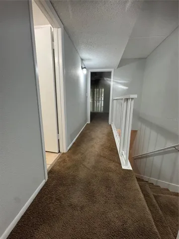 LOOKING FROM TOP OF STAIRS LANDING PAST FULL BATH WITH LINEN CLOSET TO PRIMARY BEDRM