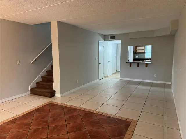 LOOKING FROM REAR PATIO THRU LOUNGING ROOM TO BREAKFAST BAR, FOYER &amp; KITCHEN