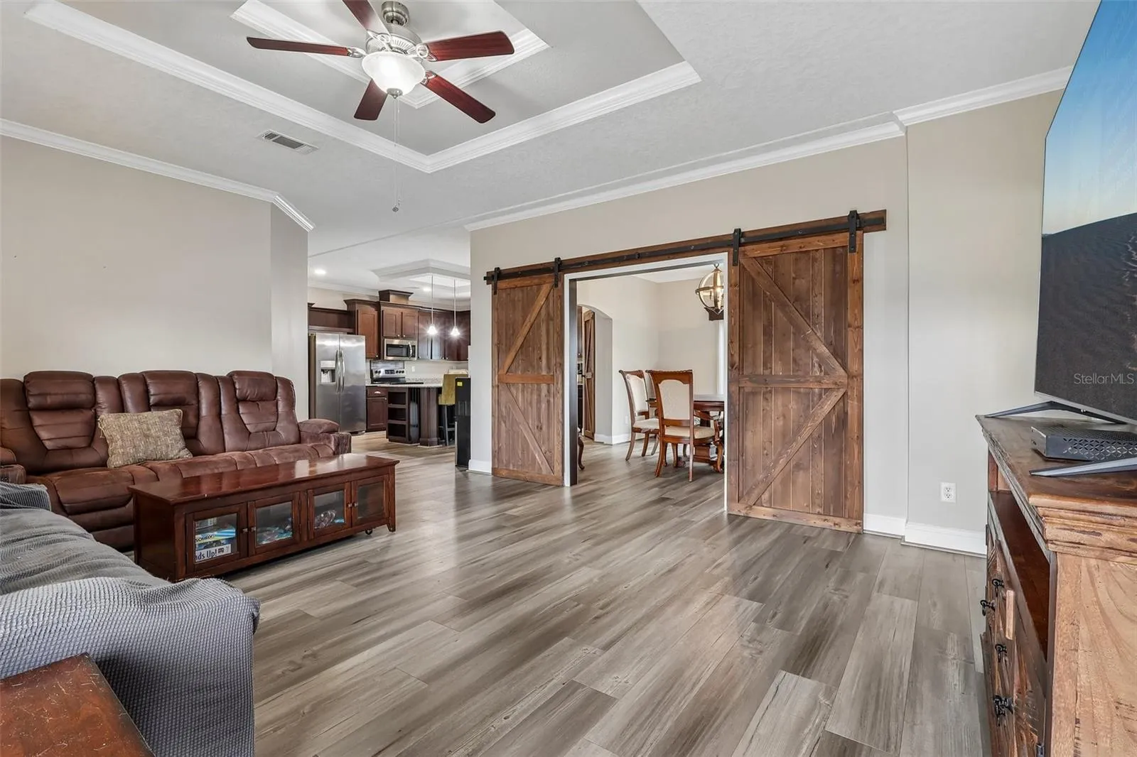 The spacious Living Room is filled with natural light and features distinctive BARN DOORS leading to the Dining Room, adding a charming touch of character while allowing the spaces to flow together beautifully.