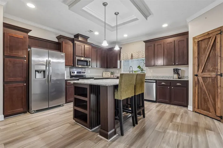 The center island includes space for counter-height seating, perfect for casual dining or conversation.