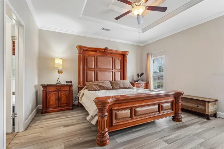 A spacious PRIMARY SUITE is privately positioned at one end of the home and features its own tray ceiling, an enormous WALK-IN CLOSET WITH BUILT-IN SHELVING, and an en-suite bath.