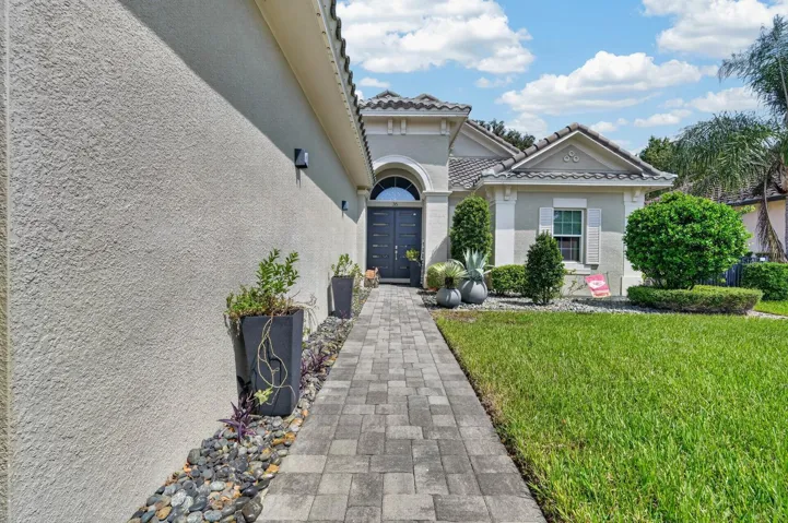 long paver sidewalk up to beautiful double door entry