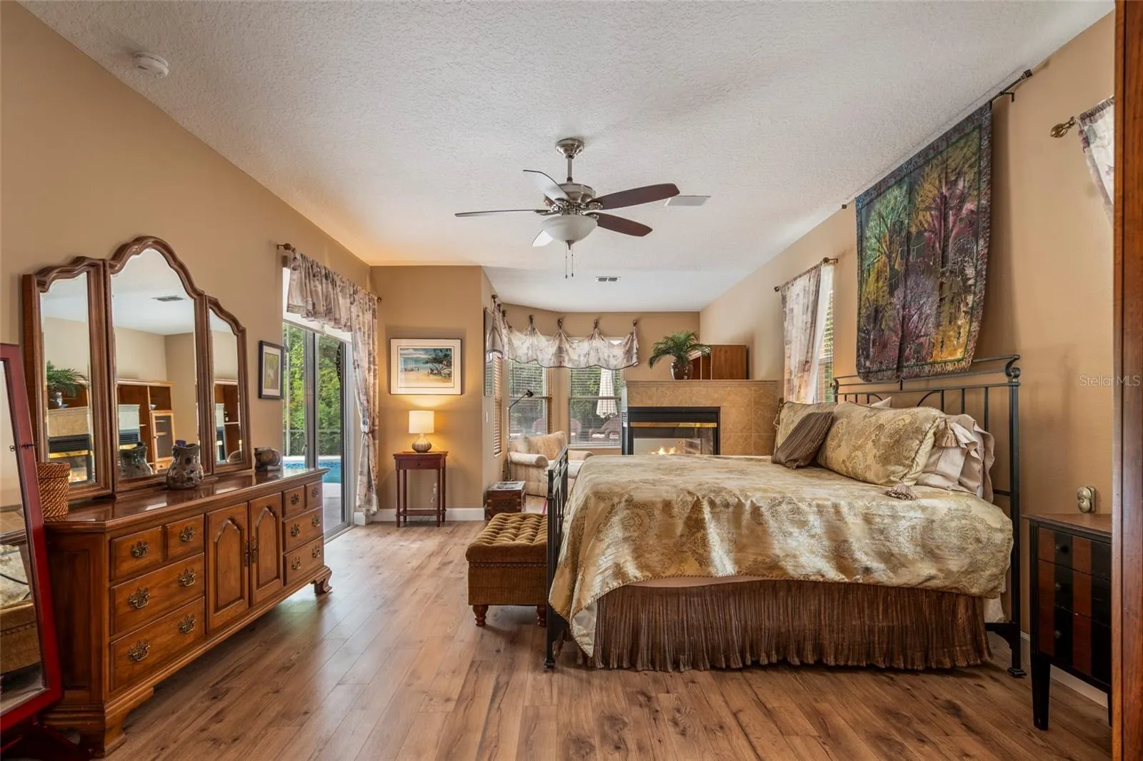 Large Primary Suite with Gas Fireplace, Sitting are and access to lanai pool area