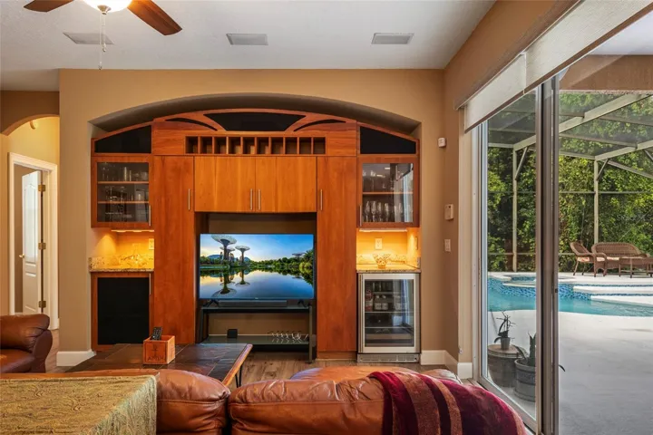 Custom Built In Entertainment Center to coordinate with kitchen cabinetry featuring a mini bar and fridge.