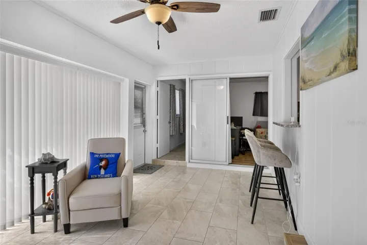 Family room with bar stools at a counter that looks through to kitchen