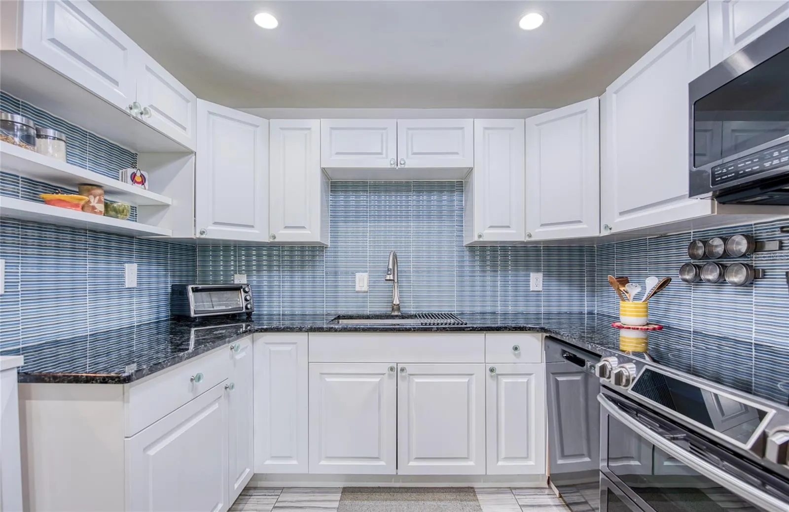 fully equiped kitchan with beautiful glass tile backsplash and newer stainless steel appliances.