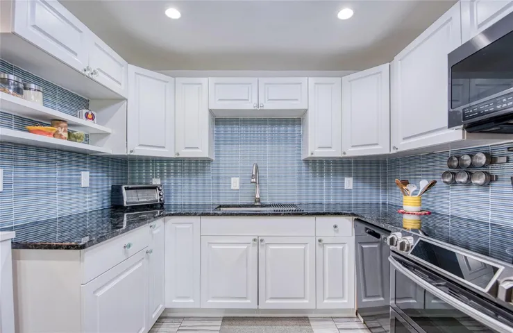 fully equiped kitchan with beautiful glass tile backsplash and newer stainless steel appliances.