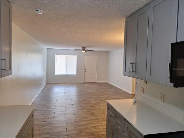 View of the living/dining area from the kitchen, showing the front entrance.