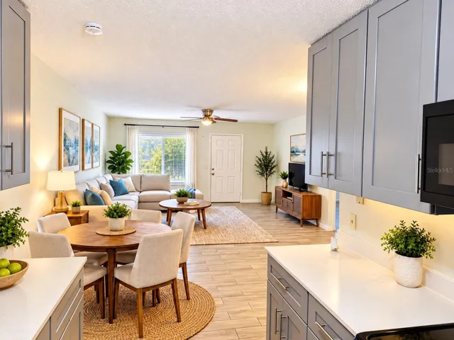 View of the living/dining area from the kitchen, showing the front entrance, Virtually enhance.
