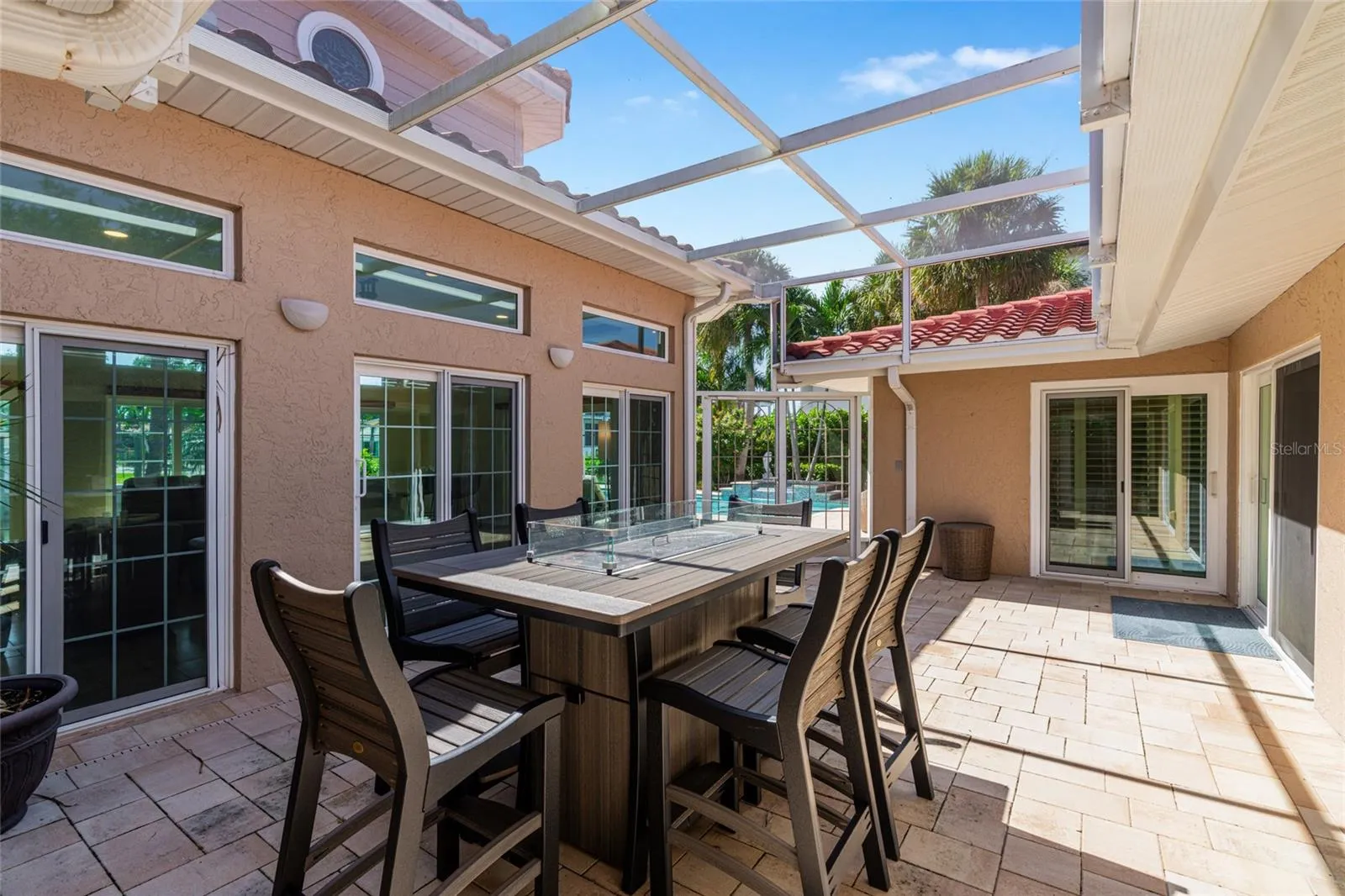 The fully screened courtyard lanai creates an inviting outdoor room at the center of the home, with space for dining and relaxing.