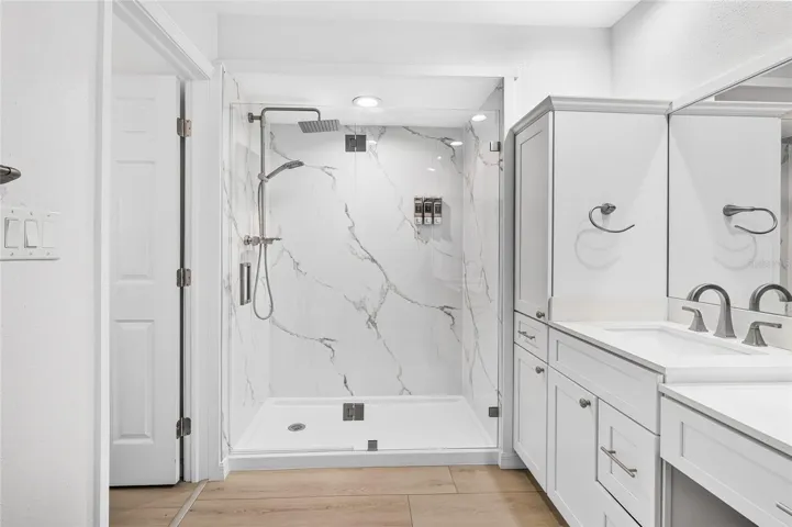 The renovated 2026 first floor primary bath features an oversized shower and upscale finishes.