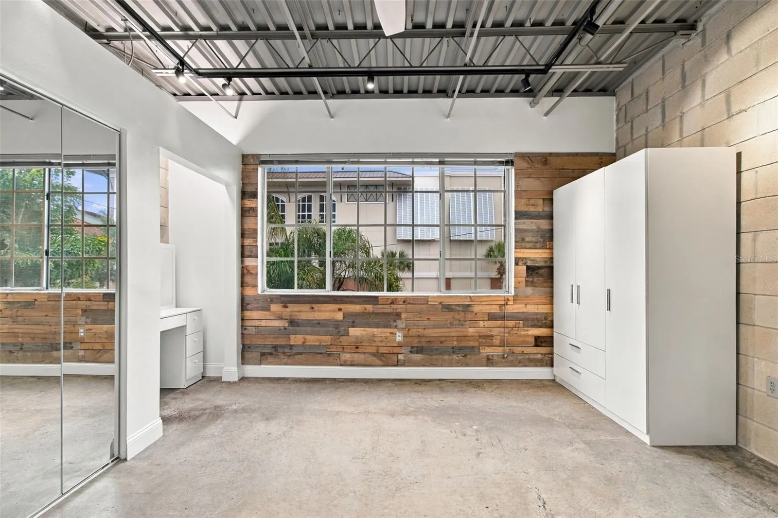 Primary bedroom includes multi-door white wardrobe closet.