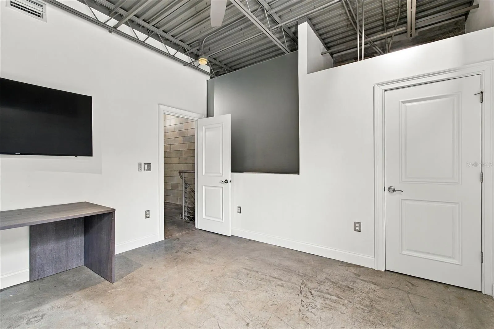 Guest bedroom features filtered frosted glass privacy wall, while maintaining the open loft concept.
