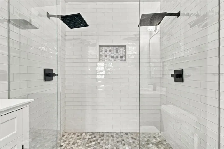 Dual rain-style shower heads featured in primary bathroom.
