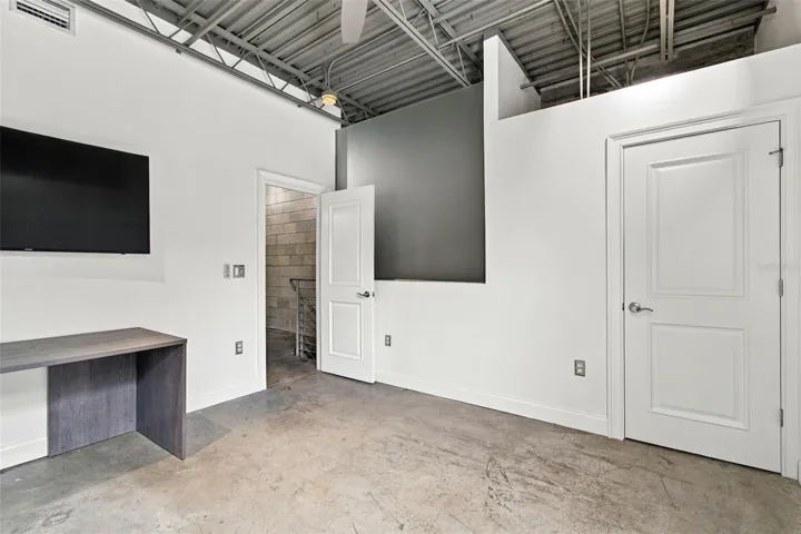 Guest bedroom features filtered frosted glass privacy wall, while maintaining the open loft concept.