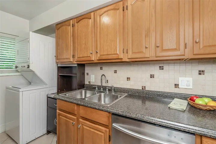 501 E Bay Dr 702, kitchen showing dishwasher and washer-dryer stack