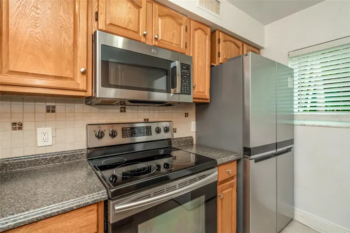 501 E Bay Dr 702 kitchen showing range, microwave and refrigerator