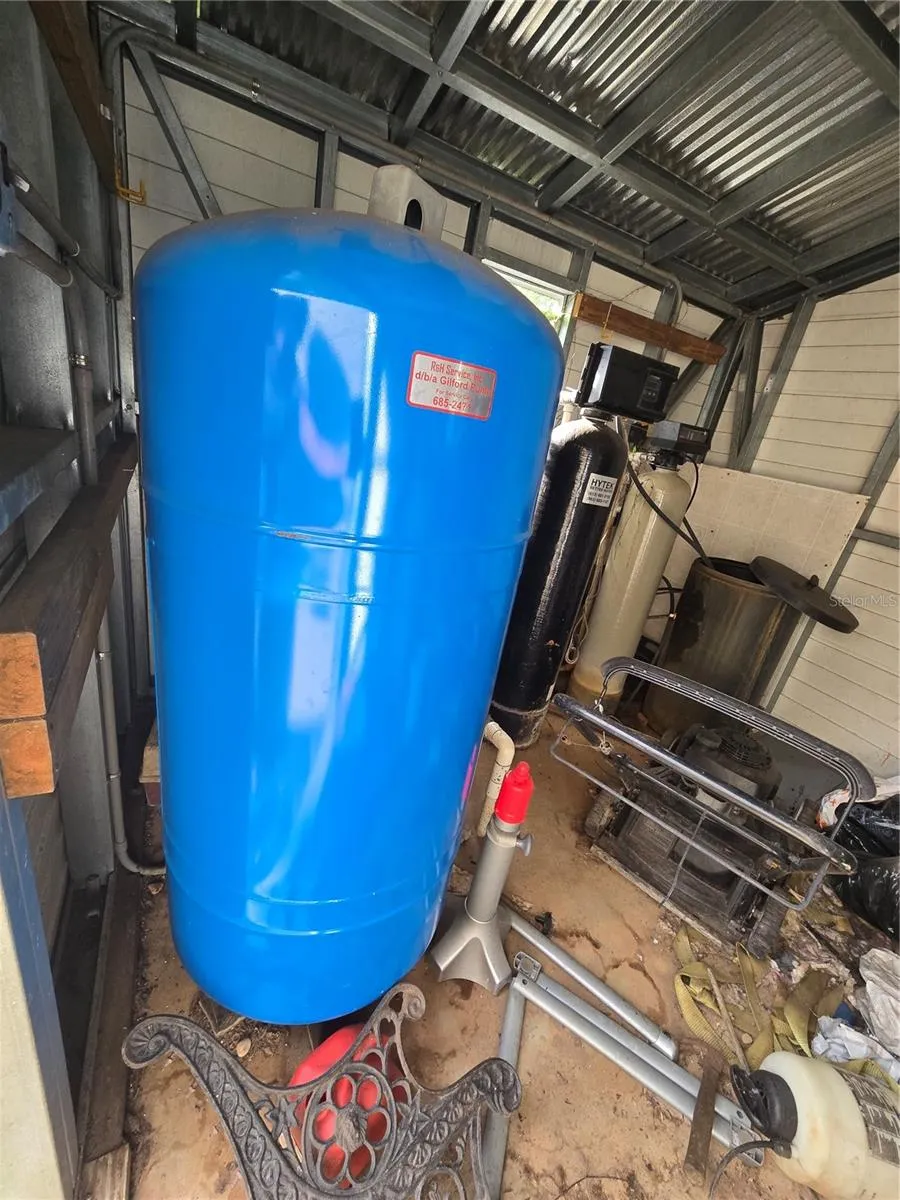 Well pump and tank inside shed.