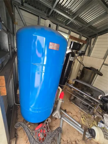 Well pump and tank inside shed.
