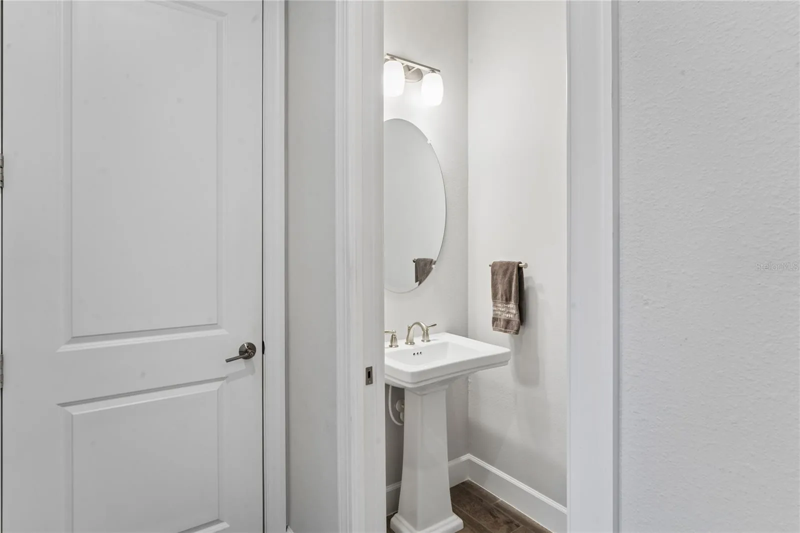 Half bath in hallway leading out to garage