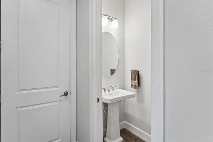 Half bath in hallway leading out to garage