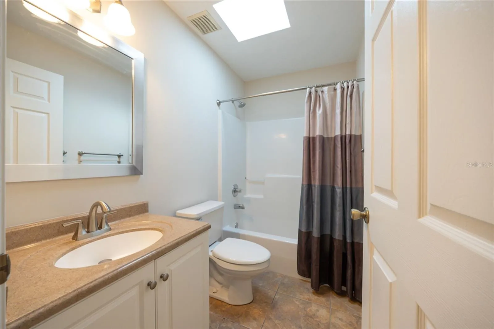 Guest bathroom has solid surface countertops and easy clean shower