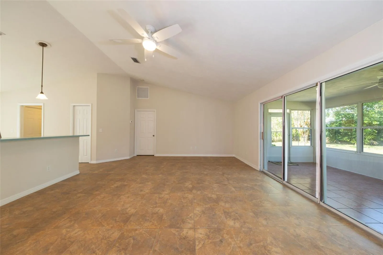 large living room, looking towards primary bedroom.  kitchen to the left, Florida room to the right.