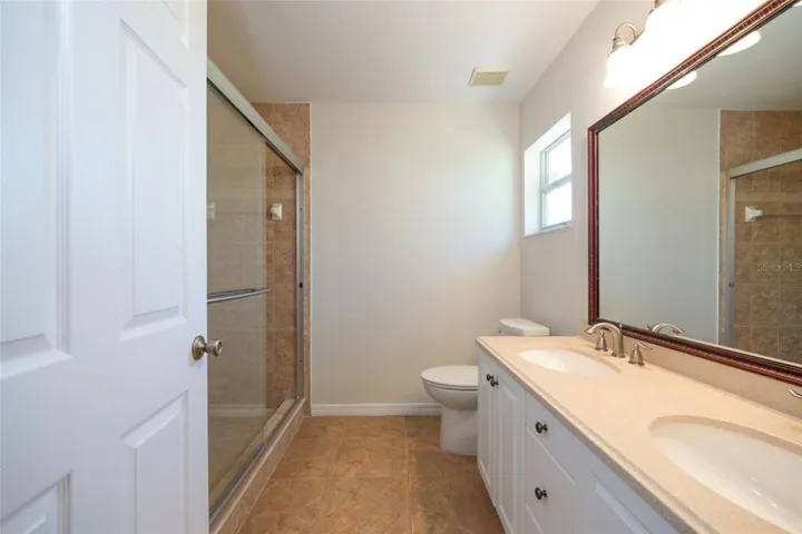 Primary bath has dual vanities and updated shower.
