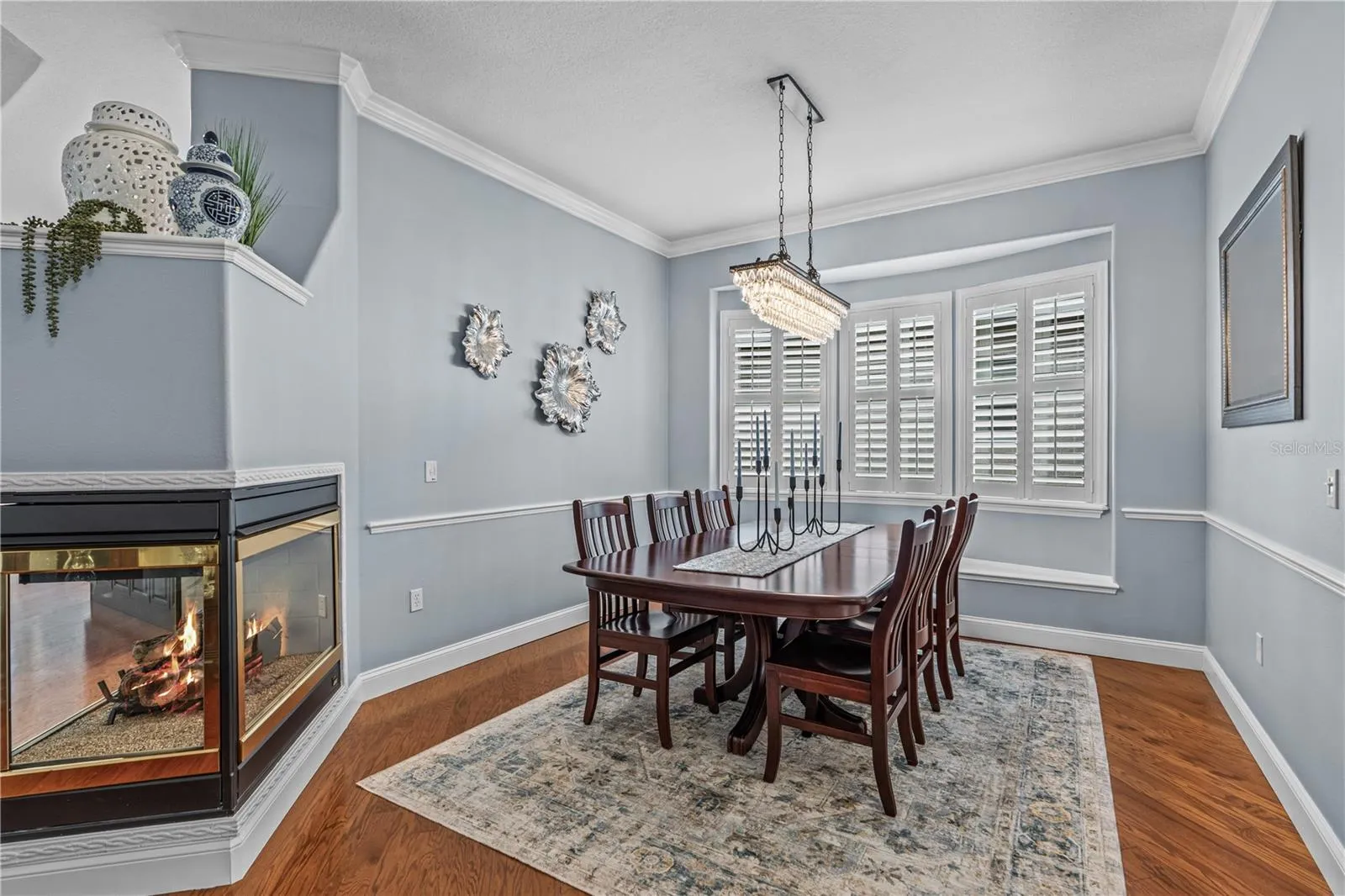 Dining room with decorative chair rail and window seat (behind the table); The fireplace is natural gas and adds warmth &amp; ambiance