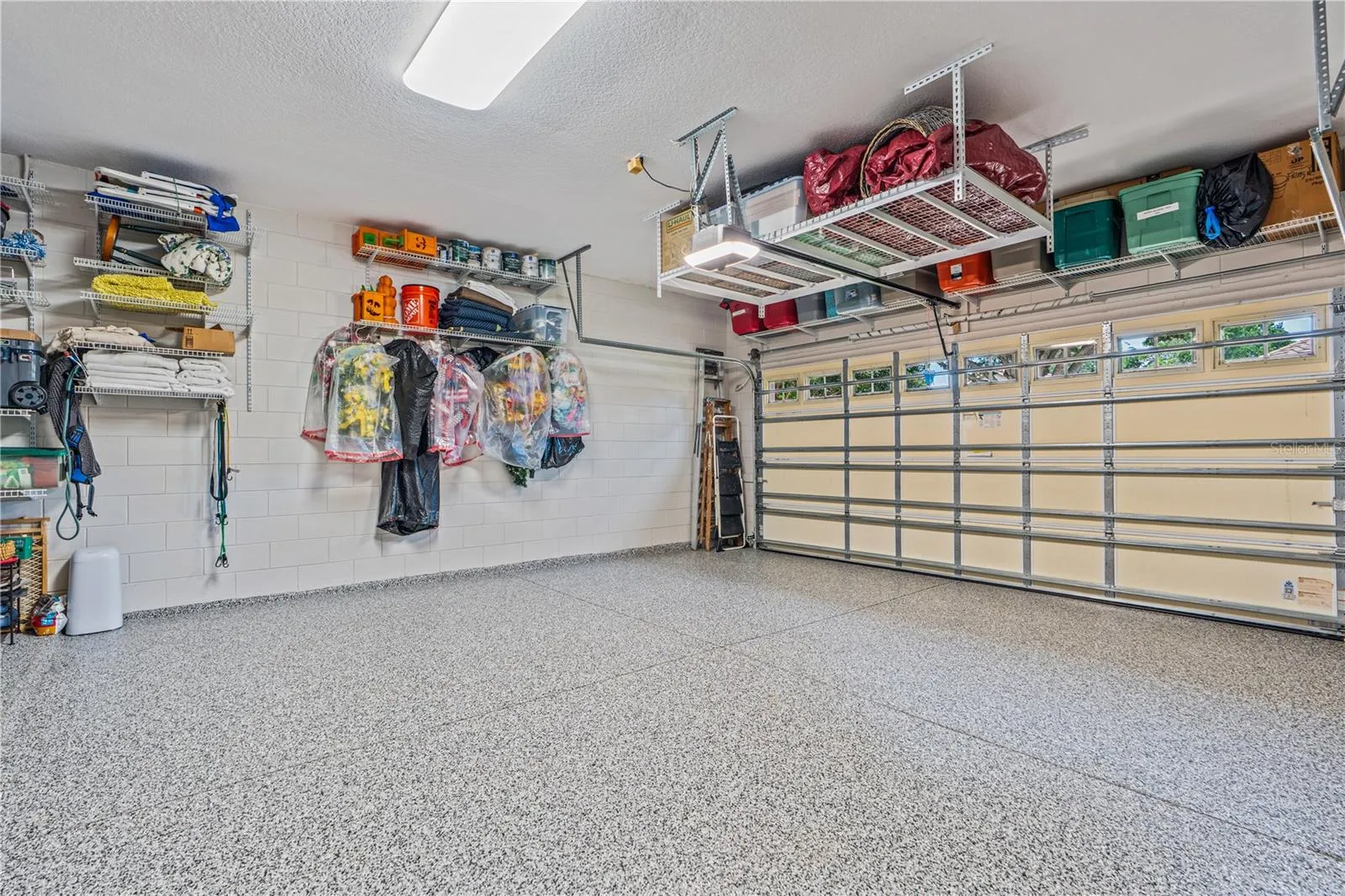 The shelving above the garage door and hanging in front of the garage door opener conveys; The shelving &amp; hangers shown on the side wall does not convey