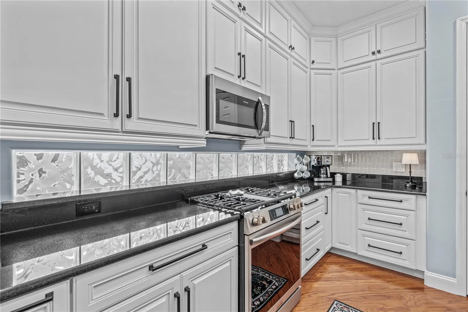 Granite on the perimeter counters with the glass block windows providing even more natural light; And check out all those drawers!