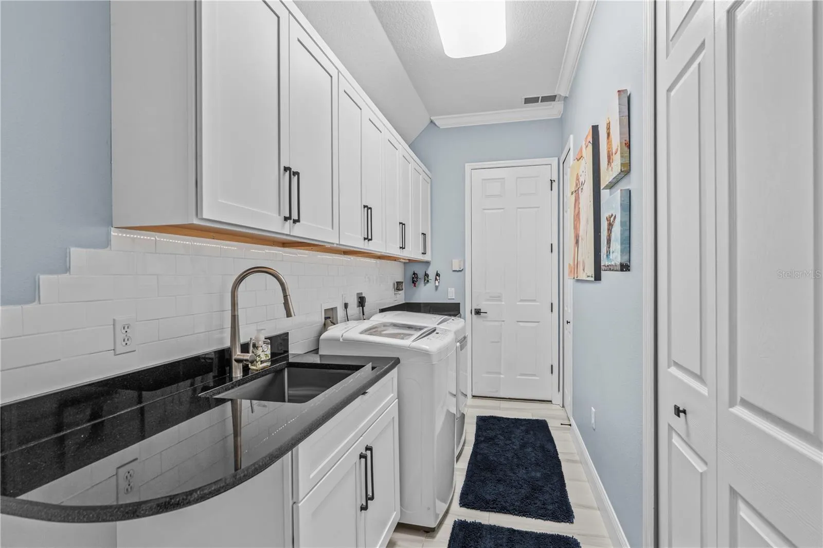 Renovated laundry room with tons more storage and granite counters; The "utility" sink-- which seems anything but utilitarian-- is stainless steel and extra deep
