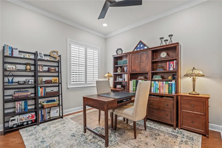 Bedroom 2 currently used as an office with hardwood floors, updated ceiling fan and can lights installed in the ceiling for extra light
