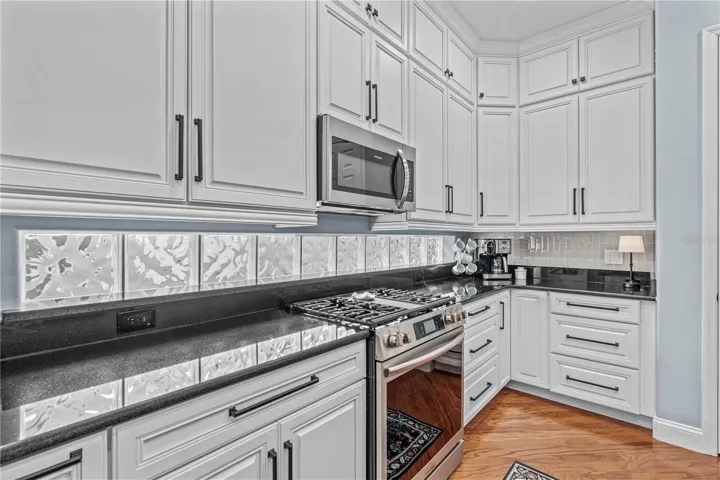 Granite on the perimeter counters with the glass block windows providing even more natural light; And check out all those drawers!