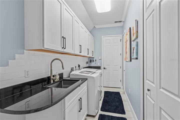Renovated laundry room with tons more storage and granite counters; The "utility" sink-- which seems anything but utilitarian-- is stainless steel and extra deep
