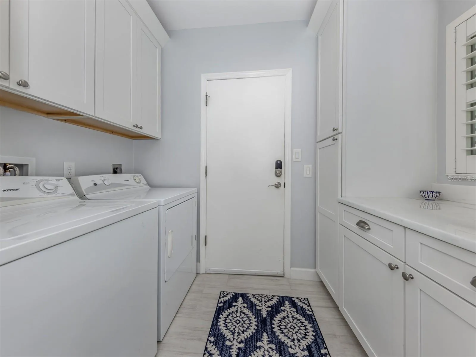 The laundry room includes plenty of extra storage and folding space