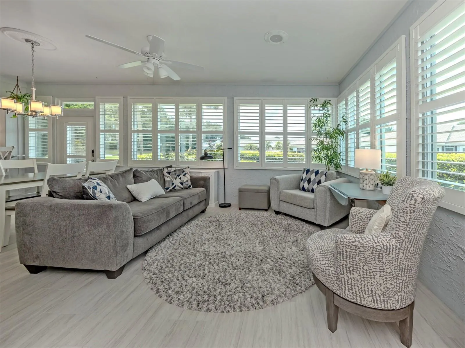 The Florida room offers custom plantation shutters and plenty of space for dining and entertaining