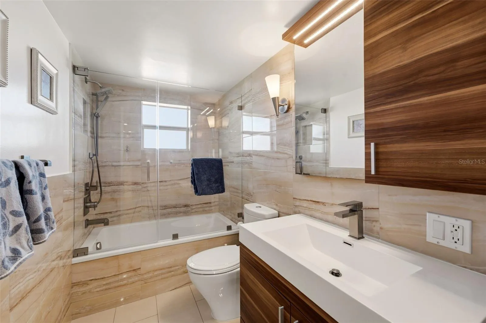 Contemporary bath with floor-to-ceiling tile and refined finishes.