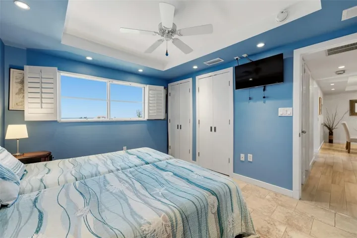 Comfortable guest bedroom with ample natural light and Gulf view.