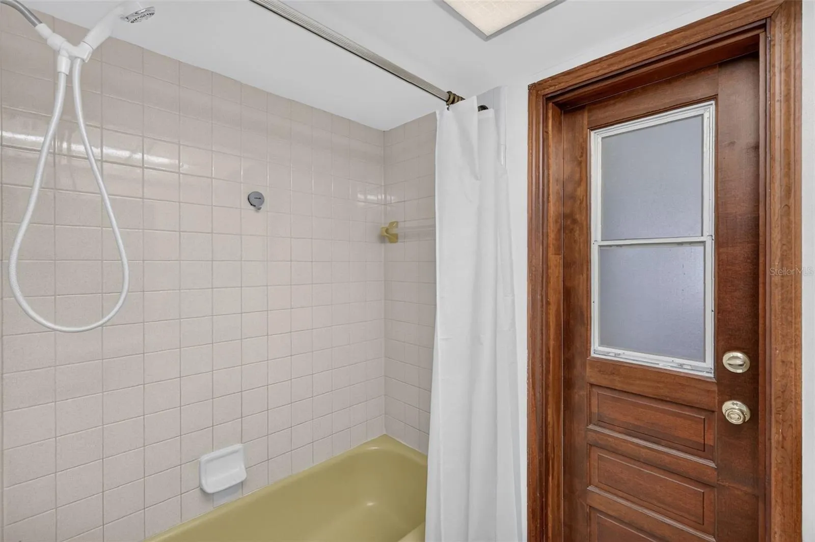 Hall bathroom tub/shower with door to screened porch