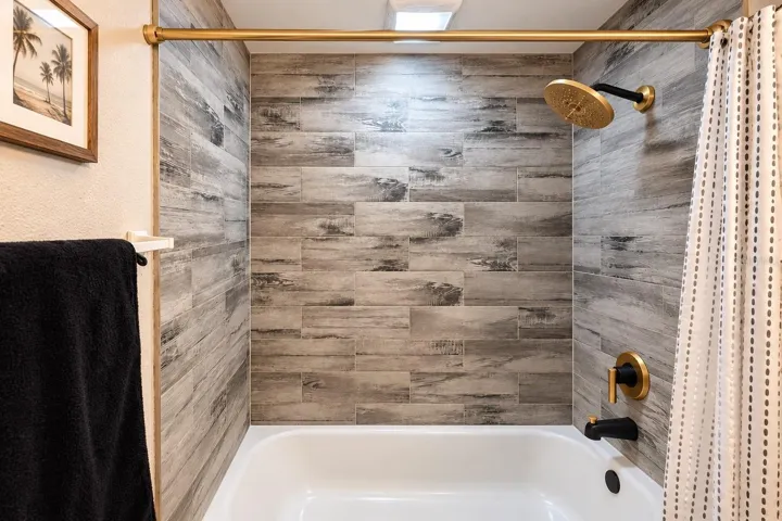 Updated bath with contemporary finishes and coordinated black-and-gold hardware.