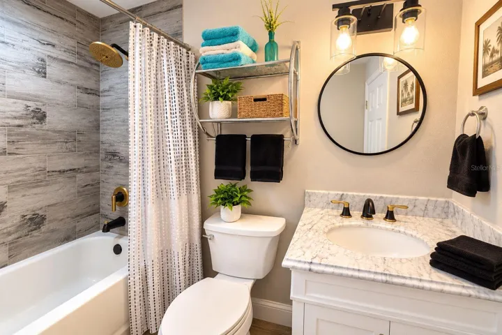 Remodeled bathroom accented by stylish black-and-gold fixtures.