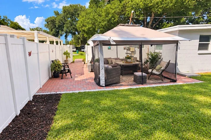 Shaded patio and canopy create a comfortable spot for morning coffee or evening relaxation.
