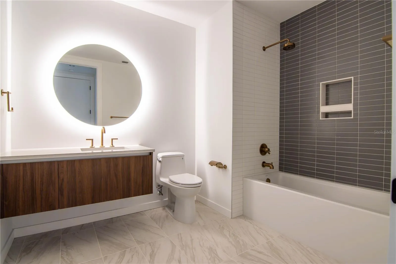 Hall bath with backlit mirror and floating vanity