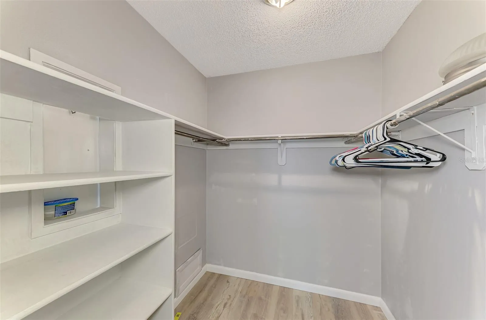 Walk in closet in primary bedroom with shelving