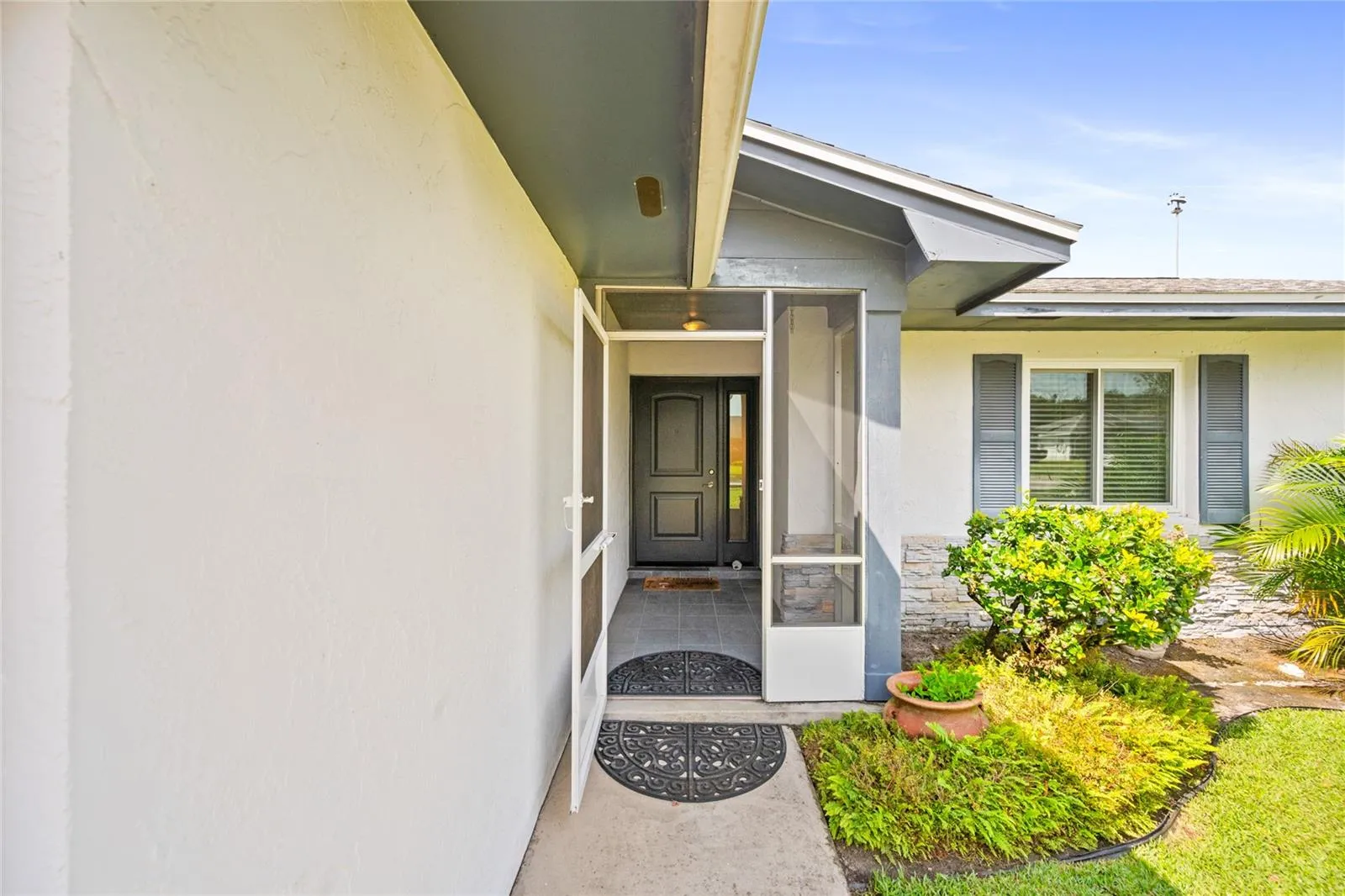 Lovely screened door leads to covered entrance.