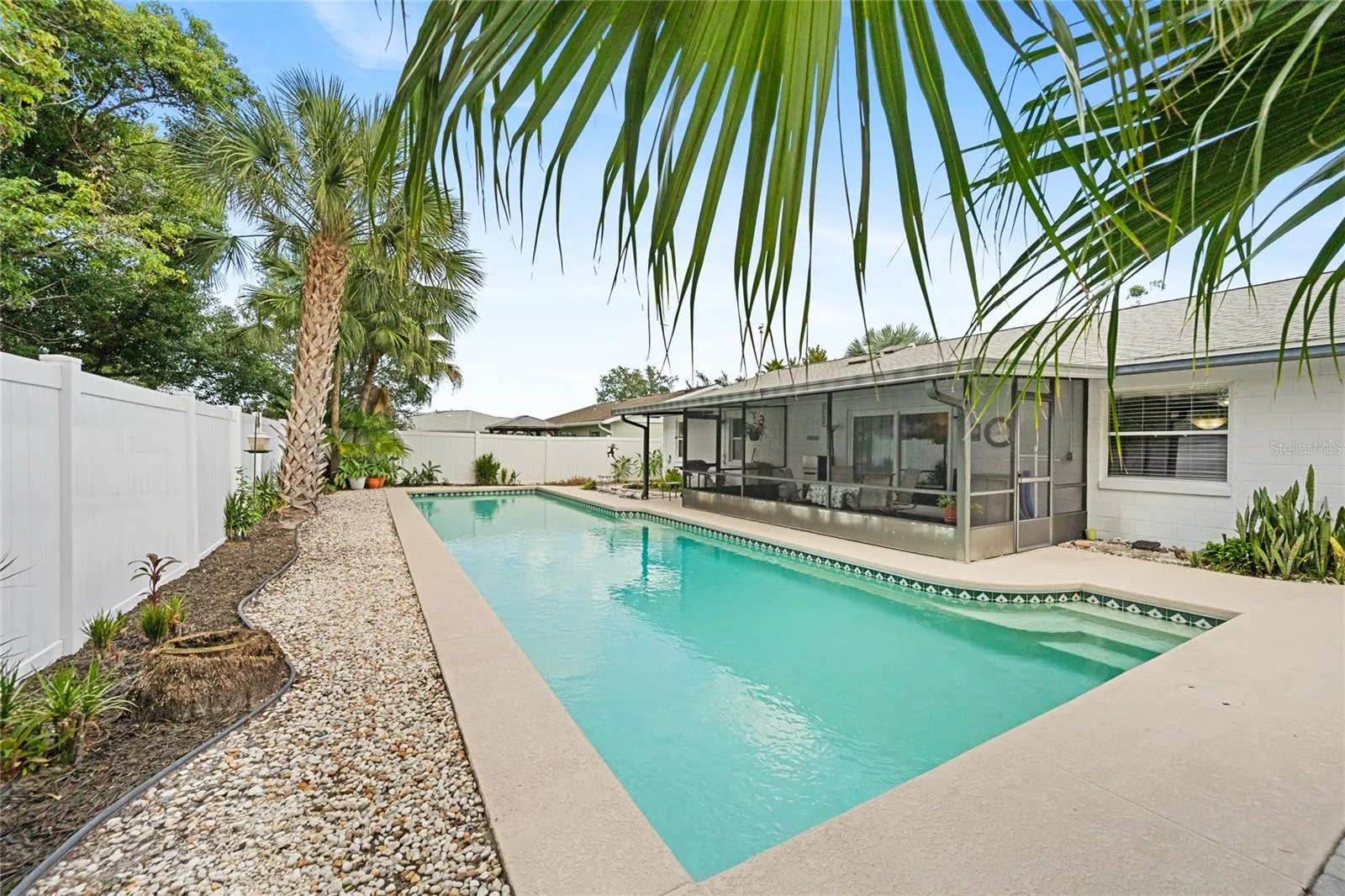 Great view of the 17' x 50' lap pool, screened patio, and large fenced in private back yard.