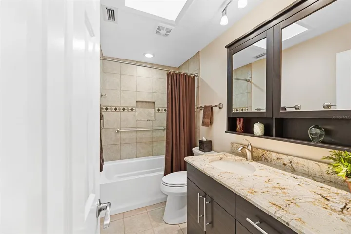Upgraded hall bath with skylight, granite counter, mirrored medicine cabinets, and bath.