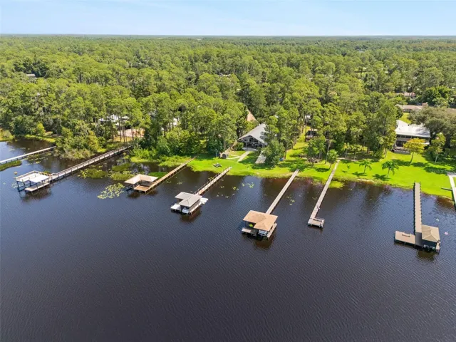 Private dock features a boat lift and covered seating area.